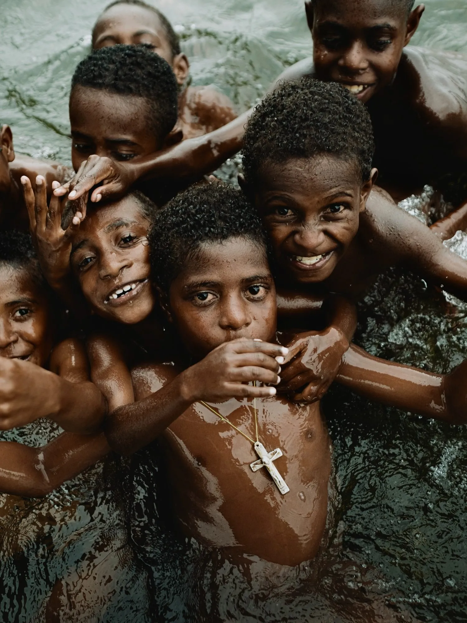 Children playing and leaping into a river in Timika, Papua